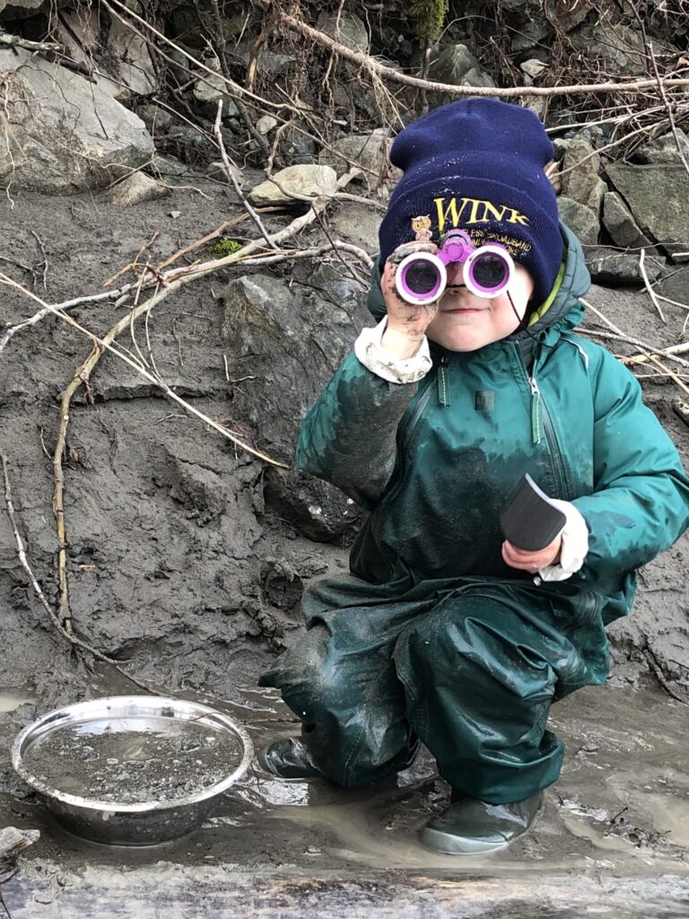 男の子が望遠鏡をのぞいてこちらを見るようす